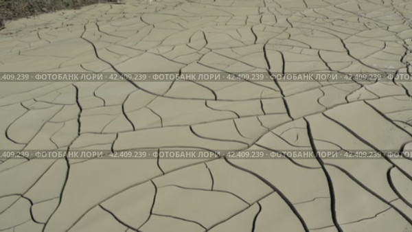 Drought effects in desert: stark, cracked earth layers. Visual evidence of drought's severity, where water once existed. Drought's impact vividly displayed in dry, fissured desert terrain. Стоковое видео, видеограф ILIA GOROKHOV / Фотобанк Лори