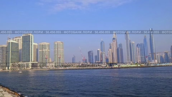 Dubai, UAE - June 26, 2025: Dubai skyline with Marina skyscrapers seen from Palm Jumeirah waterfront. Редакционное видео, видеограф Оксана Чаюн / Фотобанк Лори