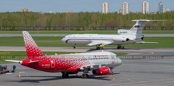 Два самолета Сухой SuperJet 100-95B "Майкоп" (RA-89174) и  Ту-154Б-2 (RA-85605) в аэропорту Пулково солнечным майским днем. Санкт-Петербург (2022 год). Редакционное фото, фотограф Виктор Карасев / Фотобанк Лори