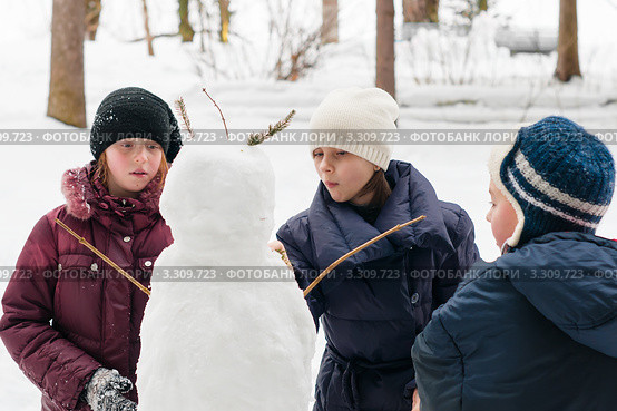 Две девочки и мальчик лепят  снеговика. Стоковое фото, фотограф Игорь Низов / Фотобанк Лори
