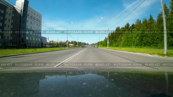 Движение мимо нового здания республиканского перинатального центра в Петрозаводске солнечным утром летом. Вид от первого лица с капота машины (2023 год). Редакционное видео, видеограф Sergei Gorin / Фотобанк Лори
