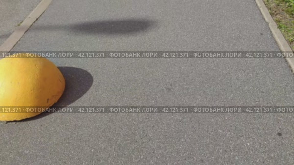 Движение по узкому тротуару. Камера движется по светло-серому асфальтовому тротуару. С одной стороны бордюр и желтые полусферы, с другой виден зеленый газон. Стоковое видео, видеограф Andrew_Swarga / Фотобанк Лори