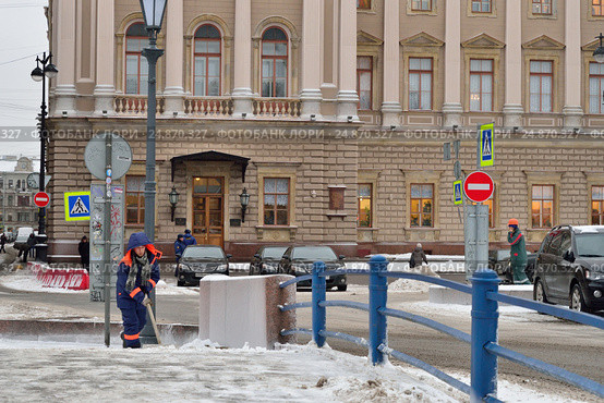 Дворник-южанин убирает снег на Синем мосту около Законодательного собрания Санкт-Петербурга (2017 год). Редакционное фото, фотограф Максим Мицун / Фотобанк Лори