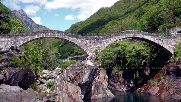 Двугорбый мост и река Верзаска. Швейцария. Май. Double Hump Bridge and the Verzasca River. Switzerland. May. (2023 год). Стоковое фото, фотограф Горшков Александр / Фотобанк Лори