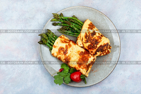 Egg omelet with asparagus and greens on grey background. Freshly made omelette with asparagus. Стоковое фото, агентство Ingram Publishing / Фотобанк Лори