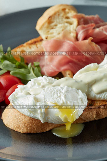 Eggs Benedict with bacon, toast, tomatoes and salad. Eggs Benedict with bacon, Стоковое фото, агентство Ingram Publishing / Фотобанк Лори