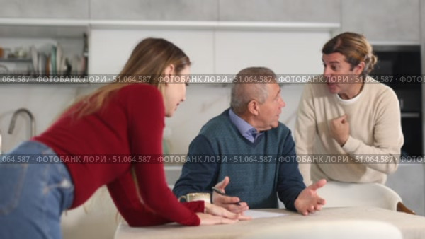 Elderly man during family quarrel with man and woman couple in kitchen. Стоковое видео, видеограф Яков Филимонов / Фотобанк Лори