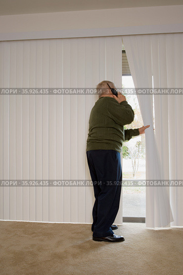 Elderly man on phone and looking out of window. Стоковое фото, фотограф Shannon Fagan / Ingram Publishing / Фотобанк Лори