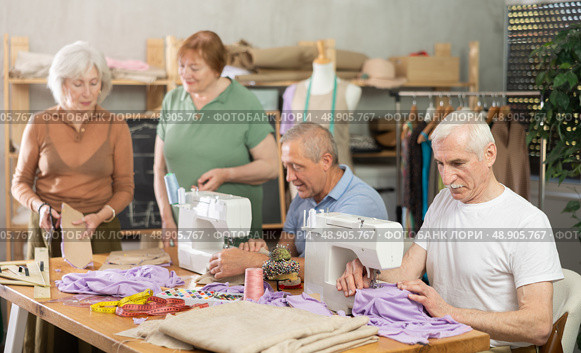 Elderly participants in sewing coterie learn sewing, communicate and talking, sewing, cut fabric by scissors. Стоковое фото, фотограф Яков Филимонов / Фотобанк Лори