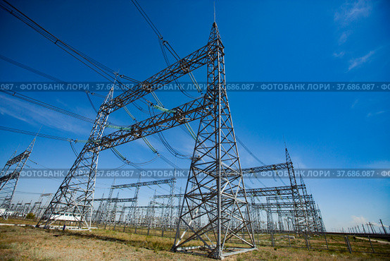 Electric transformer substation. Distribution station of electricity. Blue sky background. Стоковое фото, фотограф Alexey Rezvykh / Фотобанк Лори