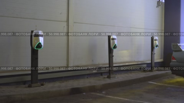 Electric Vehicle Charging Stations in a Dimly Lit Parking Area with Neon Green Lights Marking Their Presence and Readiness for Charging. Стоковое видео, видеограф Владимир Федоров / Фотобанк Лори