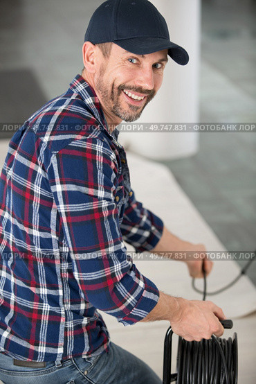 electrician with extension cord reel. Стоковое фото, агентство Ingram Publishing / Фотобанк Лори