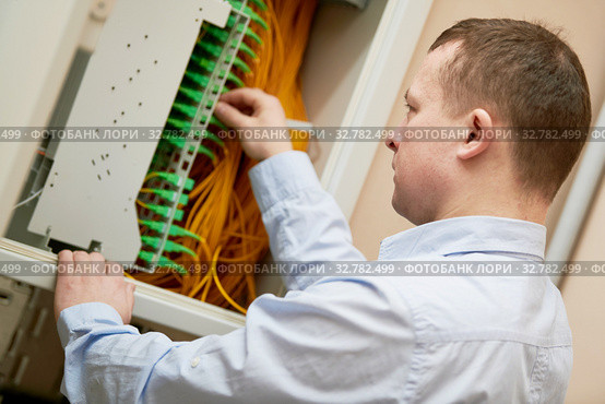 Electrician works with fiber optic cables in switchbox. Стоковое фото, фотограф Дмитрий Калиновский / Фотобанк Лори