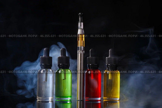 Electronic cigarette with oil on dark background with fume. Стоковое фото, фотограф Pixel_shot / Фотобанк Лори