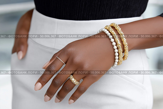 Elegant arm adorned with stylish bracelets displayed in a chic setting. Стоковое фото, фотограф Katsiaryna Repich / Фотобанк Лори