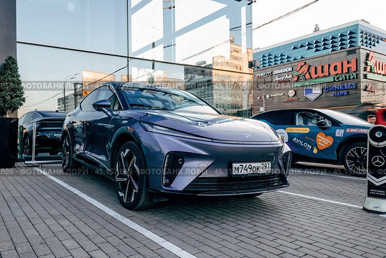 Электромобиль Rising Auto R7 перед зданием дилерского центра. Среднеразмерный электромобиль-кроссовер, выпускаемый компанией SAIC Motor (2024 год). Редакционное фото, фотограф Константин Григорьев / Фотобанк Лори