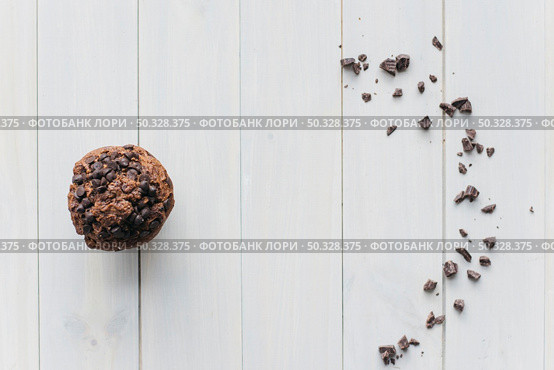 elevated view choco chip cupcake scattered chocolate wooden background. High resolution photo. elevated view choco chip cupcake scattered chocolate wooden background. High quality photo. Стоковое фото, агентство Ingram Publishing / Фотобанк Лори