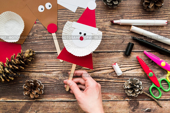 elevated view woman s hand holding santa claus prop table. Стоковое фото, агентство Ingram Publishing / Фотобанк Лори