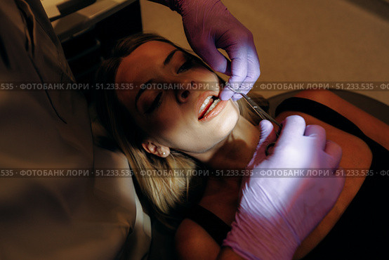 Engagement in a Dental Procedure Carried Out Under Dim Lighting for Best Results and Comfort. Стоковое фото, фотограф Cantemir Dumitru / Фотобанк Лори