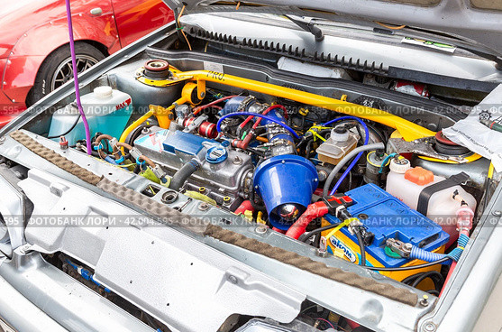 Engine under the hood of a tuning Lada vehicle with a variety of devices and improvements (2023 год). Редакционное фото, фотограф FotograFF / Фотобанк Лори