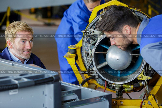 engineering teacher checking airplane engines with his students. Стоковое фото, агентство Ingram Publishing / Фотобанк Лори