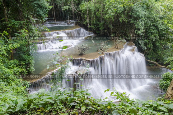 Erawan Waterfall, beautiful waterfall with sunlight rays in deep forest, Erawan National Park in Kanchanaburi, Thailand. Стоковое фото, агентство Ingram Publishing / Фотобанк Лори