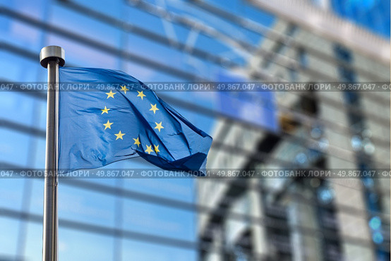 European Union flags in front of the blurred European Parliament in Brussels, Belgium. Стоковое фото, агентство Ingram Publishing / Фотобанк Лори
