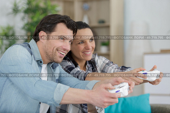 excited male and female hipsters rejoice in winning a video-game. Стоковое фото, агентство Ingram Publishing / Фотобанк Лори