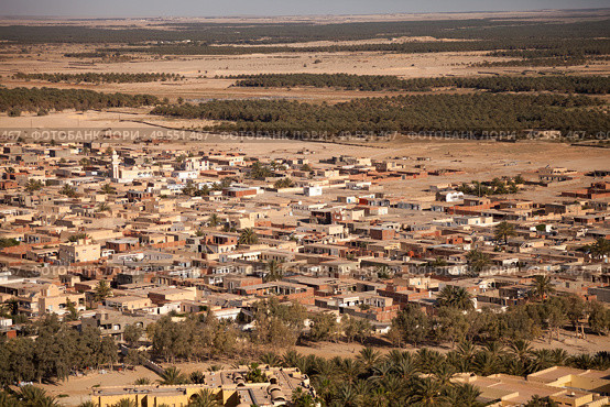 Expansive View of a Desert Oasis Town in the Sahara, Bordered by Lush Palm Groves and Arid Landscape. Стоковое фото, фотограф Aleksandr Golubev / Фотобанк Лори