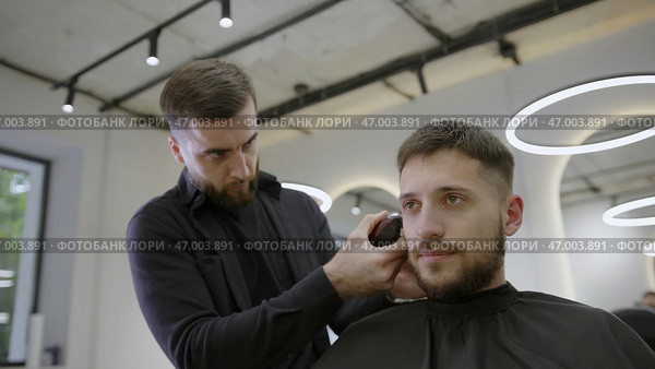 Experience an exceptional Barber Styling Haircut in a sophisticated and modern salon today. Стоковое фото, фотограф David Kashakhi / Фотобанк Лори