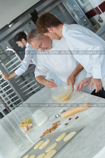 experienced baker teaching male apprentice. Стоковое фото, агентство Ingram Publishing / Фотобанк Лори