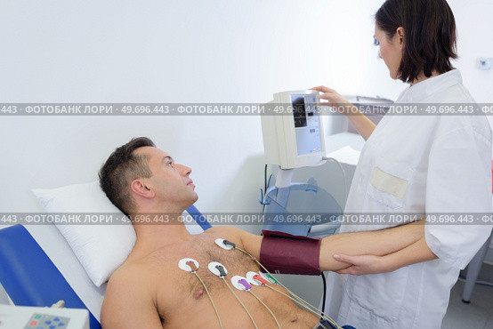 experienced cardiologist attaching sensors to patients chest. Стоковое фото, агентство Ingram Publishing / Фотобанк Лори
