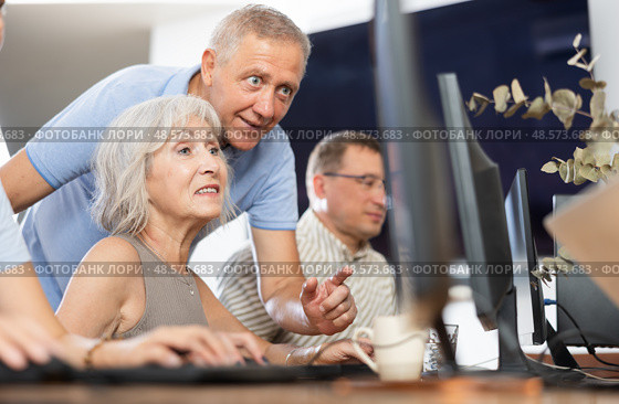 Experienced teacher of computer class assisting enthusiastic woman. Стоковое фото, фотограф Яков Филимонов / Фотобанк Лори