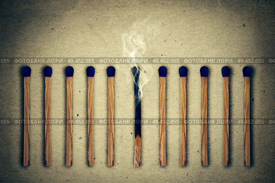 Extinguished, burnt match between a row of whole, new matches. Стоковое фото, агентство Ingram Publishing / Фотобанк Лори