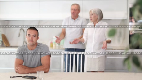 Family of threen - mother, father and son quarrel in kitchen. Eldery cuple is disappointent of adult son. Стоковое видео, видеограф Яков Филимонов / Фотобанк Лори