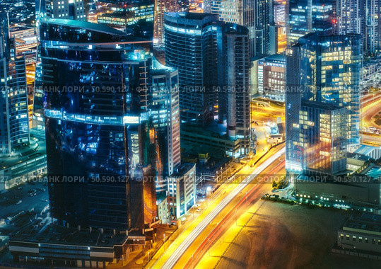 Fantastic rooftop view of a big modern city architecture at night with roads. Business bay, Dubai, United Arab Emirates. Стоковое фото, агентство Ingram Publishing / Фотобанк Лори