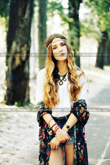 Fashion portrait of beautiful hippie young woman wearing boho chic clothes and summer hat outdoors. Soft warm vintage color tone. Artsy bohemian style. Стоковое фото, агентство Ingram Publishing / Фотобанк Лори