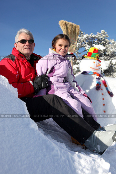 Father and daughter with snowman. Стоковое фото, агентство Ingram Publishing / Фотобанк Лори