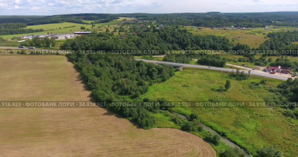 Federal road passing through the agricultural fields, woods in middle part of Russia. Aerial view. Стоковое видео, видеограф Кекяляйнен Андрей / Фотобанк Лори