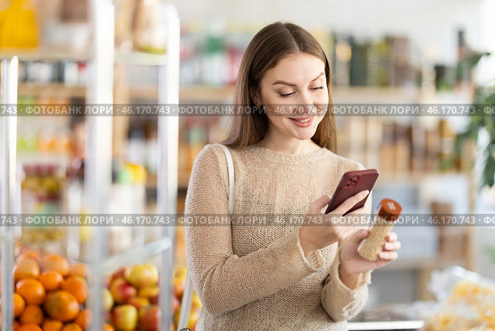 Female buyer checks suitability - scans QR code on seasonings herbs label in grocery store. Стоковое фото, фотограф Яков Филимонов / Фотобанк Лори