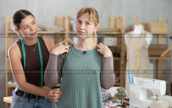 Female client and dressmaker checking tailored gown fit in studio. Стоковое фото, фотограф Яков Филимонов / Фотобанк Лори