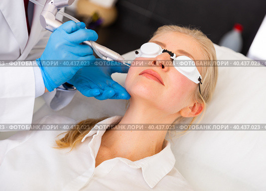 Female client receiving face skin laser resurfacing at cosmetology clinic. Стоковое фото, фотограф Яков Филимонов / Фотобанк Лори