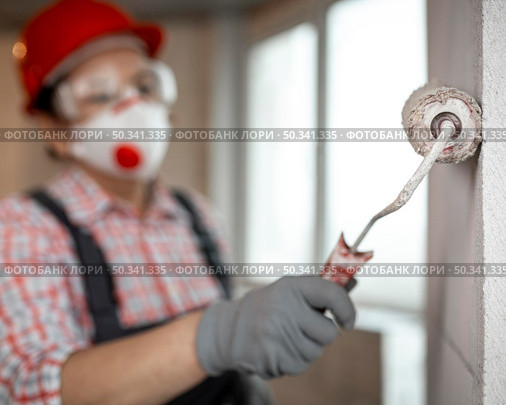 female construction worker with helmet paint roller. Стоковое фото, агентство Ingram Publishing / Фотобанк Лори