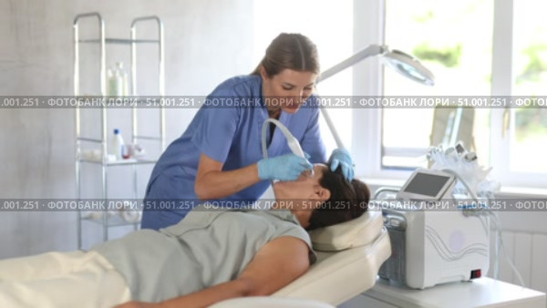 Female doctor doing cosmetology procedure for elderly woman, RF lifting and deep hydration for facial skin therapy in clinic. Стоковое видео, видеограф Яков Филимонов / Фотобанк Лори