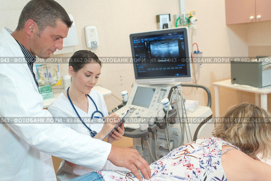 female doctor making ultrasound investigation in medical clinic. Стоковое фото, агентство Ingram Publishing / Фотобанк Лори