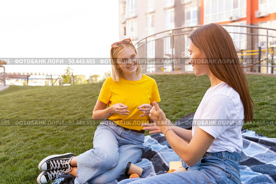 female friends outdoors using sign language. Стоковое фото, агентство Ingram Publishing / Фотобанк Лори