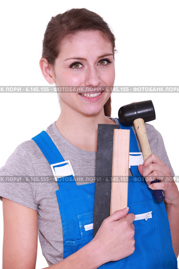 Female labourer holding mallet and sand paper. Стоковое фото, фотограф Phovoir Images / Фотобанк Лори