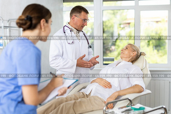 Female nurse and male doctor carries out survey of mature female patient about allergic reactions. Стоковое фото, фотограф Яков Филимонов / Фотобанк Лори