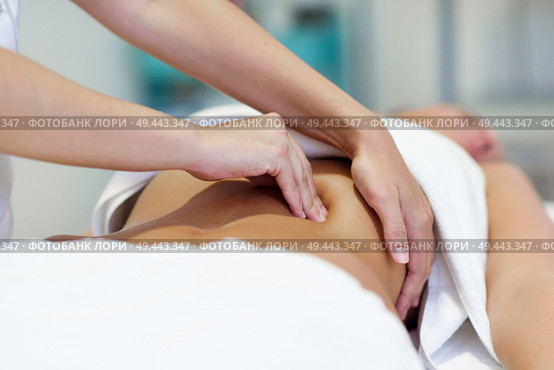 Female patient is receiving treatment by professional osteopathy therapist. Woman having abdomen massage in a physiotherapy center.. Woman having abdomen massage by professional osteopathy therapist. Стоковое фото, агентство Ingram Publishing / Фотобанк Лори
