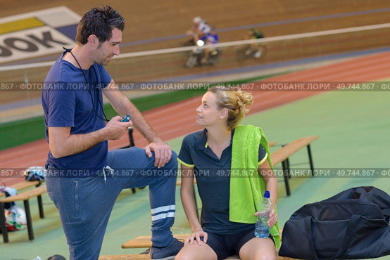 female racing cyclist on velodrome talking to coach. Стоковое фото, агентство Ingram Publishing / Фотобанк Лори